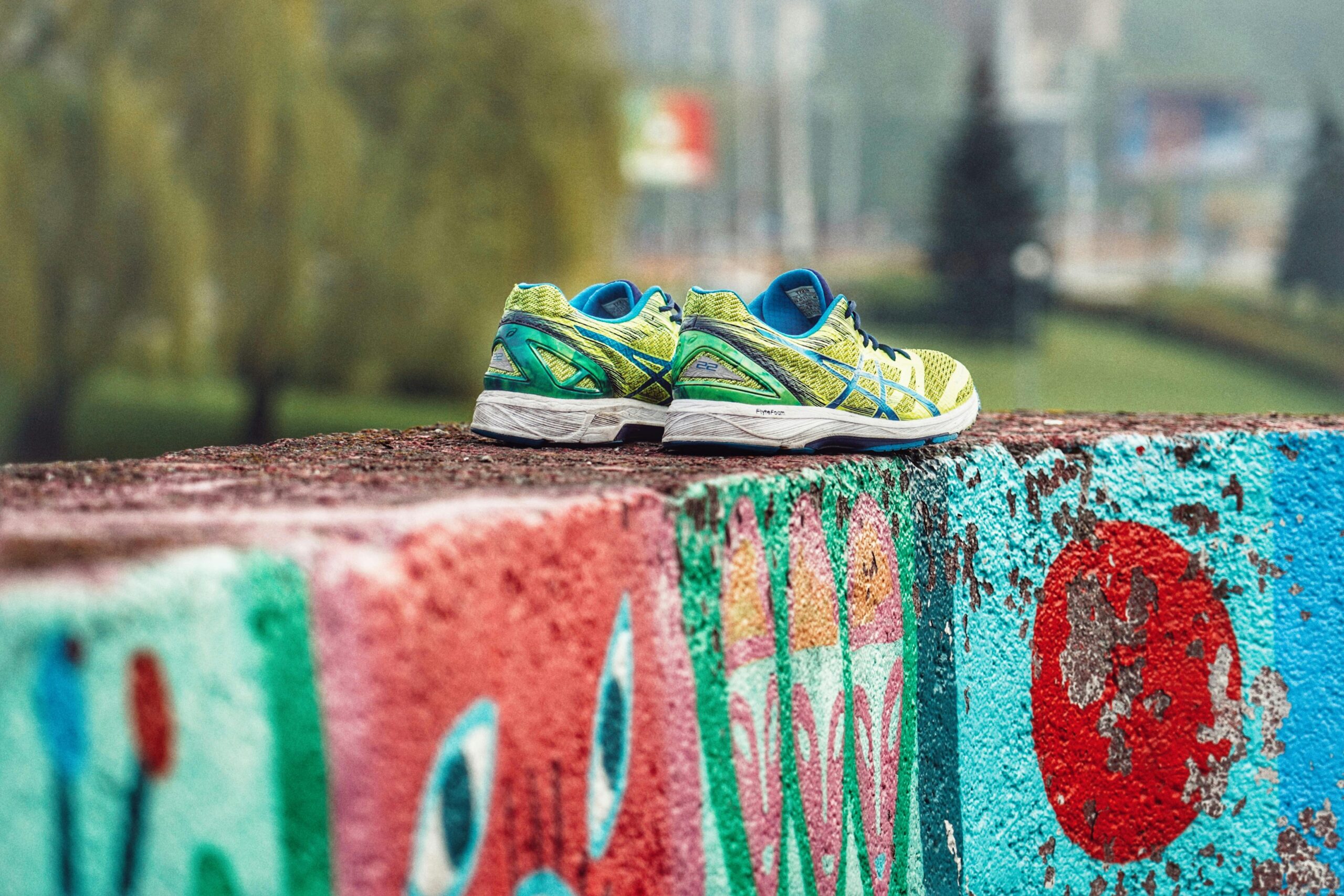 A pair of running shoes left by colorful graffiti — the visual of an environment designed to make the practice the path of least resistance.